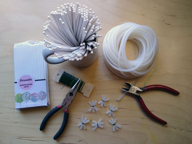 Photograph of materials and tools for building models of polyhedra: 6" plastic cake-pop sticks; flexible silicone rubber tubing; 22-gauge steel wire; needle nose pliers; wire cutters.